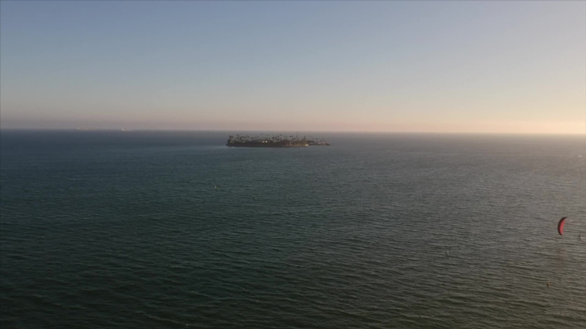 Drone at high altitude flying over the ocean with the view of a small island. Long Beach, CA
