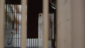 prison corridor through steel bars. the camera moves from right to left and goes behind the wall - Powered by Shutterstock - Get 15% off with code: PIKWIZARD15