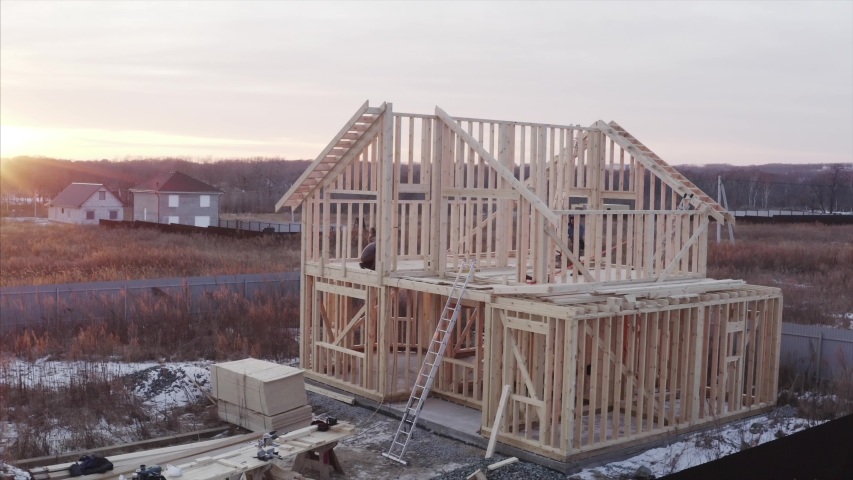 Aerial panoramic view of wooden frame house under construction, builders are working on the second floor Royalty-Free Stock Footage #1044003175