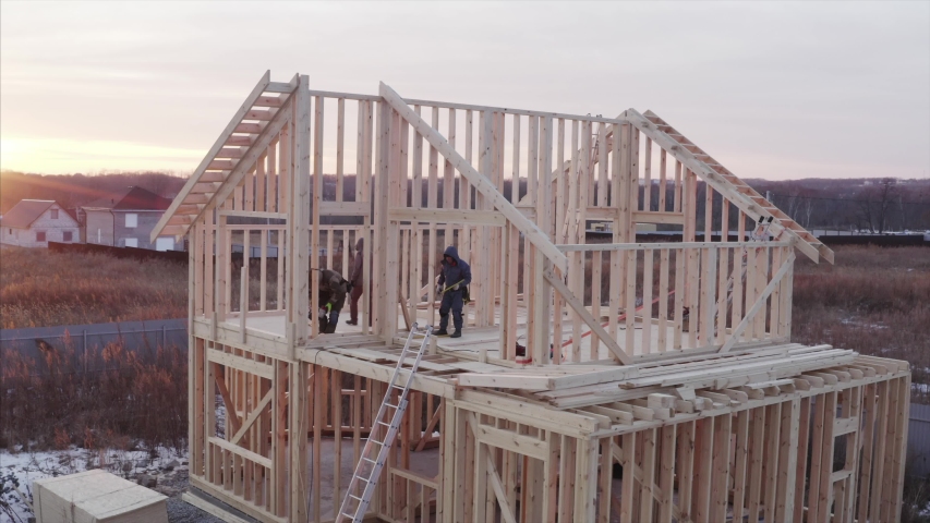 Aerial panoramic view of residential frame house under construction, builders are working on the second floor Royalty-Free Stock Footage #1044003184