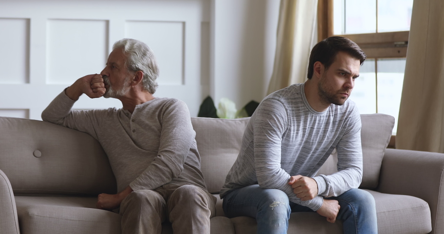 Angry frustrated stubborn senior old father and young adult grown son sit on sofa turn back ignore each other think of family conflict, two age generation gaps and problem in bad relationship concept Royalty-Free Stock Footage #1044003367