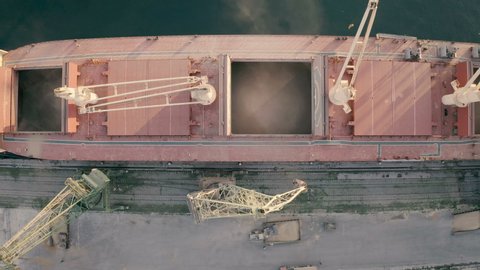 Top view from drone of a large ship loading grain for export. Water transport 