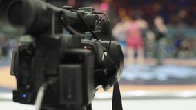 Cameraman with a camera in wrestling competitions. Close-up.