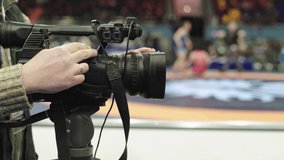 Cameraman with a camera in wrestling competitions. Close-up.