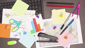 Business plans, laptop and office supplies appear on grey background - Stop motion  - Powered by Shutterstock - Get 15% off with code: PIKWIZARD15