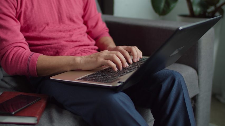 Close-up of hands of hearing impaired man communicating with sign language during video conference online using laptop on sofa. Deaf-mute male with laptop pc online messaging using sign language. Royalty-Free Stock Footage #1044019834