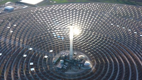 Sun reflecting on giant mirrors concentrated solar power Gemasolar Spain aerial shot 