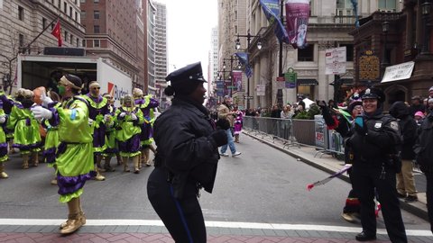 Philadelphia, Pa - January 1, 2020: A black policewoman in uniform seen dancing in the street while on duty at the New Years Day Philadelphia Mummers Parade on this cold day