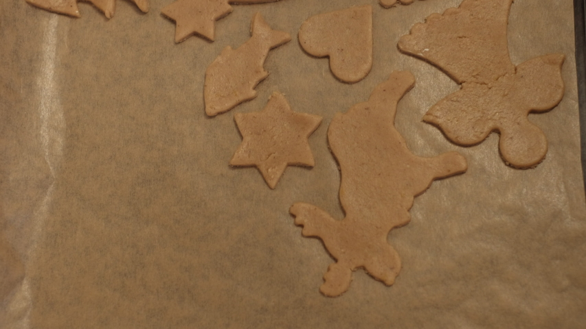 Freshly cut Christmas gingerbread cookie placed on baking tray. 4K resolution top view shot on a gimbal. Czech Republic