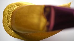 Golden smear of liquid paint texture, on white background. Painting Gold metallic paint with a brush close-up. Art. Leaking Lipgloss, nail polish, make-up. 4K UHD video - Powered by Shutterstock - Get 15% off with code: PIKWIZARD15