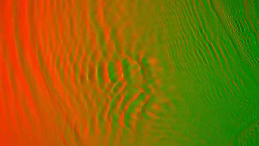 Super Slow Motion Abstract Shot of Swirling Green and orange Neon Water at 1000fps. Royalty-Free Stock Footage #1044064846