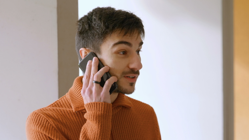 young man talking on the phone with his friend and smiling