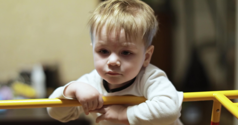 One year old boy on the gymnastic stairs watching TV