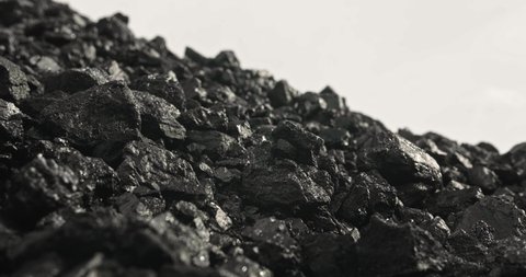 Coal close-up. Panorama of pile of coal in slow motion. Carbon concept in 4k. Shiny pile of anthracite on white background. Stone ore close-up in slow motion. Natural minerals