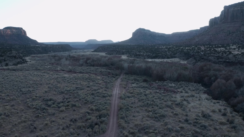 desert dirt road with cliffs and stream in southern utah
