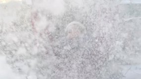 Young happy teenager beautiful smiling girl throwing snow in the air in winter Christmas new year holidays. Woman raising hands happy to Russian heavy snowfall. Slow motion close up portrait video.