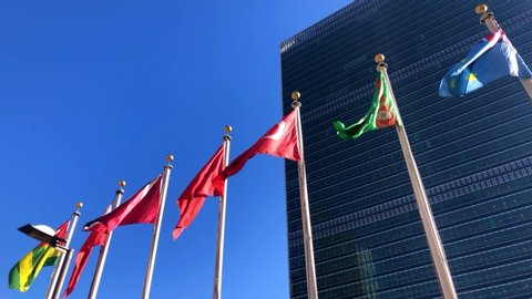 New York - January 2, 2020: The United Nations building in Manhattan, the official headquarters of the UN since 1952, and the flags of its member countries.