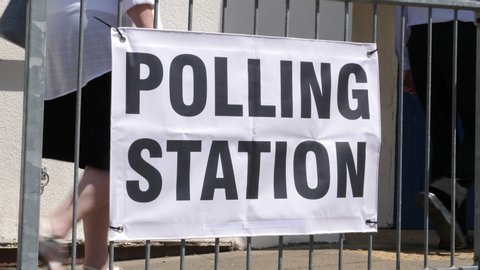 Polling Station Sign - People walking past and going to vote in the election. Politics.  -4K Stock Video clip footage