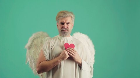 Funny Man as the cupid with a wings congratulating on St Valentines day. Valentine giving heart. Valentines Day. Portrait of male Angel
