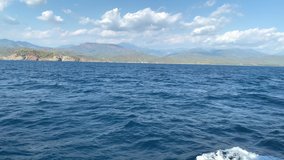 Sailing on the pleasure boat near islands in the sea. Summer vacation. Ocean view. Mountains. 4k video