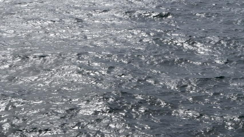 Mesmerizing waves and ripples of shimmering ocean, dolly left