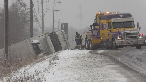 Hamilton, Ontario, Canada January 2020 Truck rolled over with tow truck in snow after winter storm makes road slippery