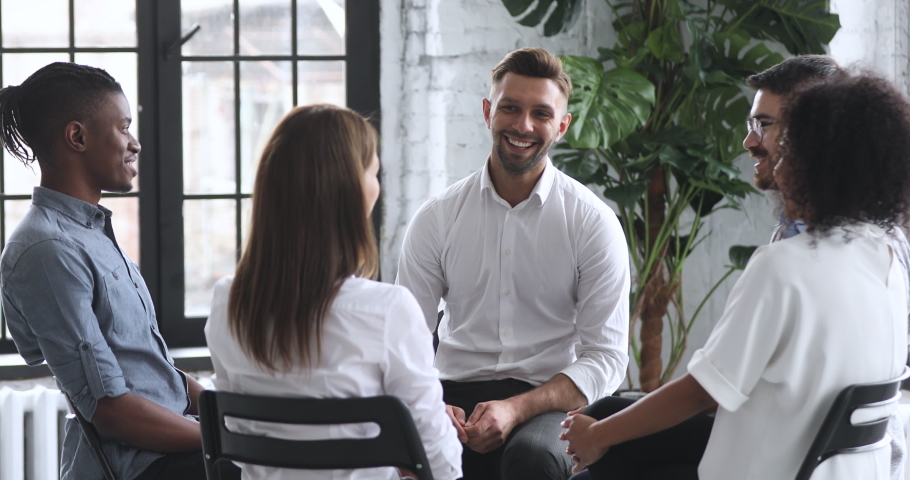 Smiling male coach psychologist talk to diverse people patients group sit in circle at therapy session, counselor therapist help with problems at psychotherapy rehab meeting business training concept Royalty-Free Stock Footage #1044100441