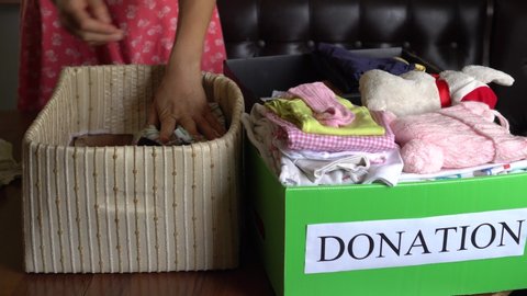 Disposing of reusable things: clothing, shoes, household goods, textiles, furniture and other things that can be reused. Woman donates to charity, the Red Cross or orphanages, homes for the elderly