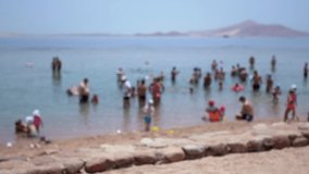 Blurry defocused footage of many people enjoying hot summer days at beach of Egypt. 4k video.