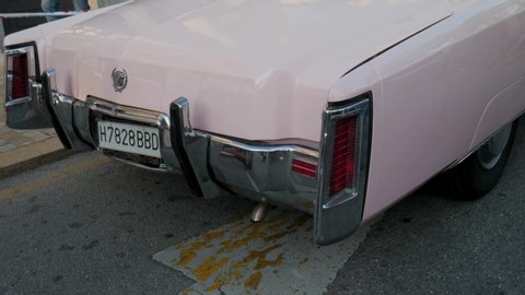 Malaga/Spain - 01-05-2020 : rear pan shot of a pink vintage eldorado Cadillac parked outdoor on the street