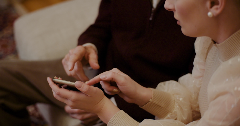 Female Teaching Grandfather To Use Cellphone In Christmas