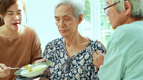 Unhappy asian senior woman rejecting,gesture hand “NO” elderly patient bored with food or boredom,old people getting sick and tired of food in wheelchair at home,loss of appetite,anorexia concept