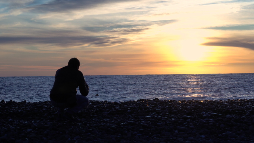 A man admires the sunset near the sea.