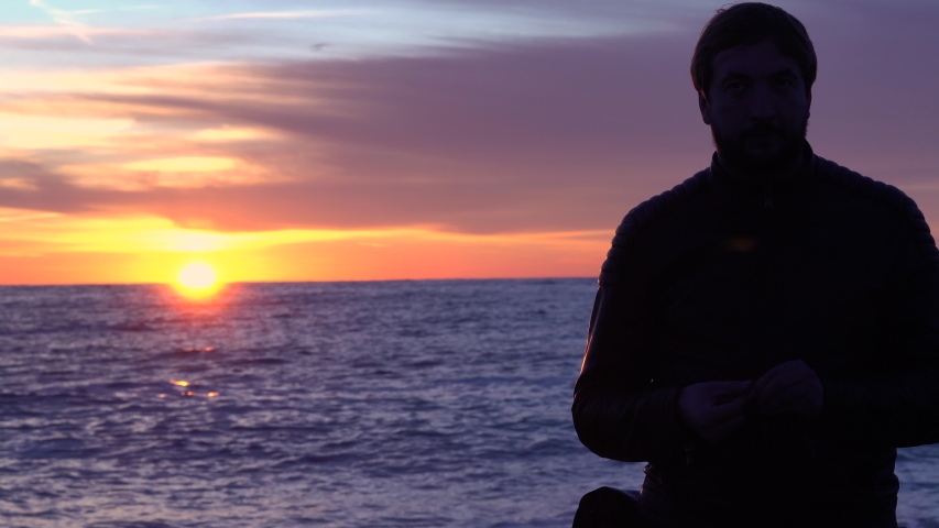 A man admires the sunset near the sea.