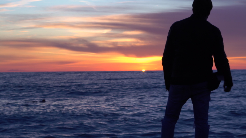 A man admires the sunset near the sea.