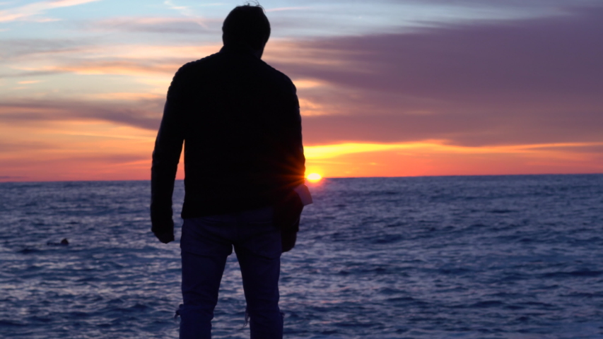 A man admires the sunset near the sea.