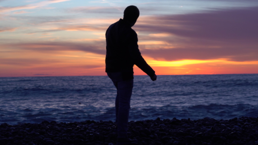 A man admires the sunset near the sea.