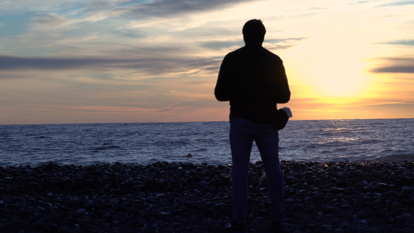 A man admires the sunset near the sea.