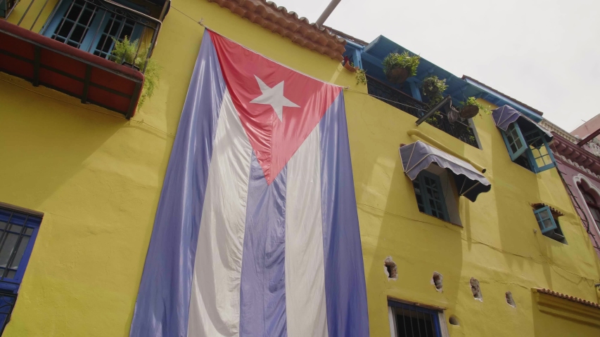 Huge Cuban flag on yellow building in Havana, La Habana (Havana), Cuba, West Indies, Caribbean, Central America