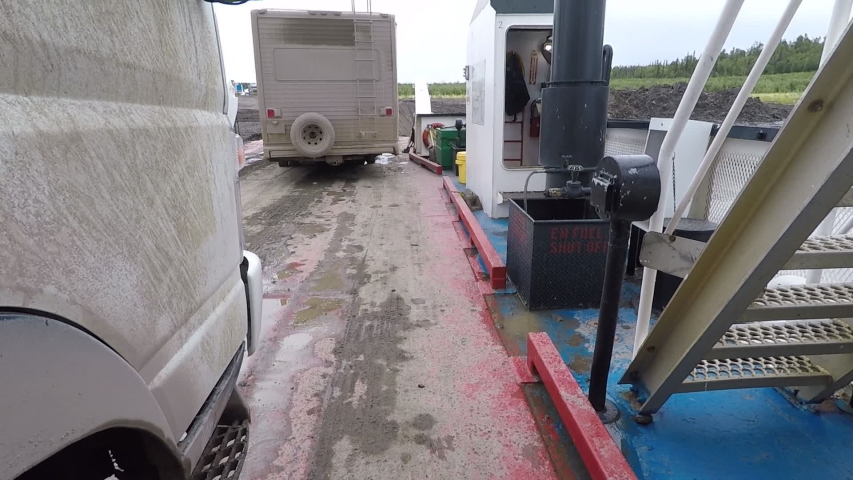 Truck and RV getting off the river ferry in arctic, Truck side POV. Dempster Highway, Canada.