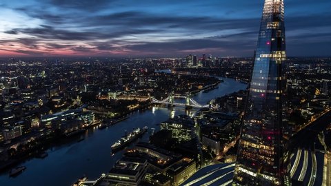 Establishing Aerial View Shot of London City Skyline Shard and Tower Bridge in foreground, Canary Wharf in background United Kingdom sunrise dusk wonderful colors of the sky