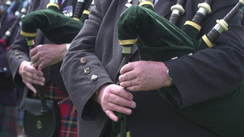 Bagpipers in Scotland wearing tradional tartan kilts playing the pipes. Scottish culture