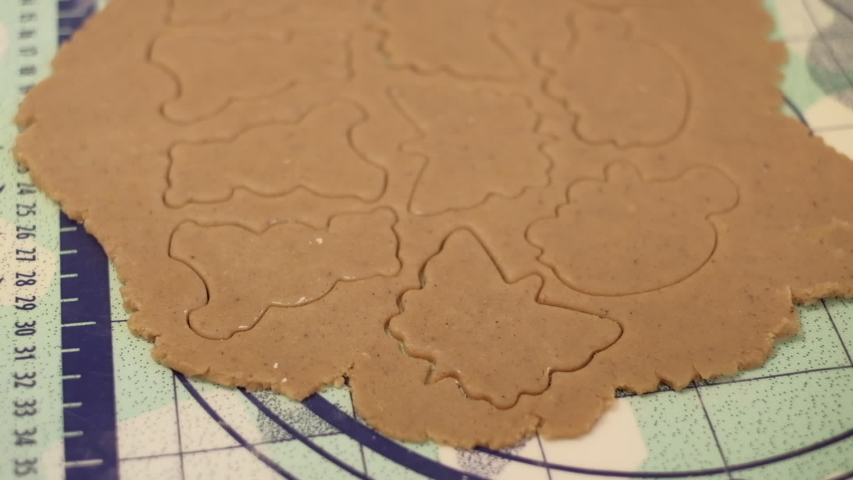 Raw dough with cut out gingerbread cookies and plastic cutters in shapes of animals . Slow motion close up shot on a gimbal. Czech Republic