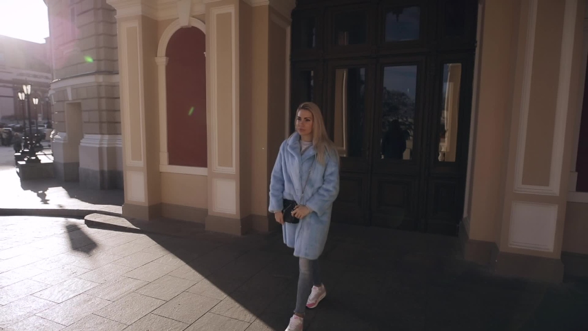 Beautiful blonde woman enjoying sunny winter day standing in palace looking around