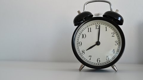 4K Black alarm clock on a white table background,Alarm at 8 O'clock