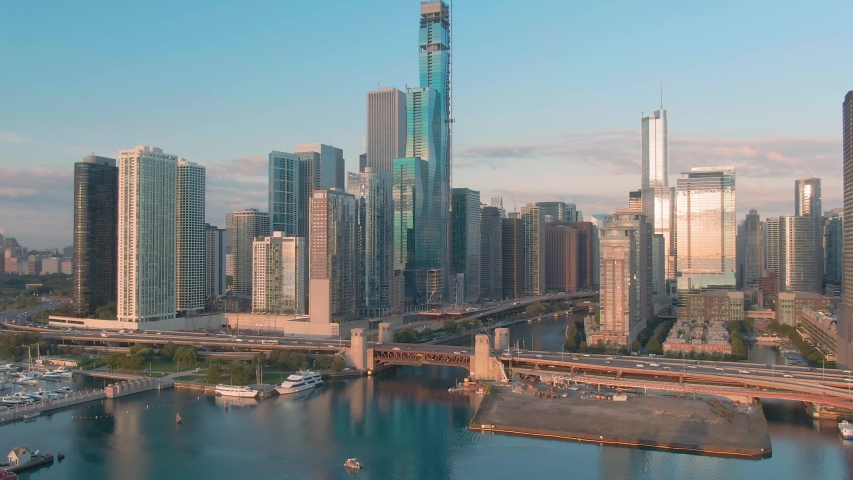 Aerial: Rush hour traffic on South Lake Shore Drive alongside Lake Michigan at sunrise. In the background is the Chicago city skyline. Chicago, Illinois, USA. 