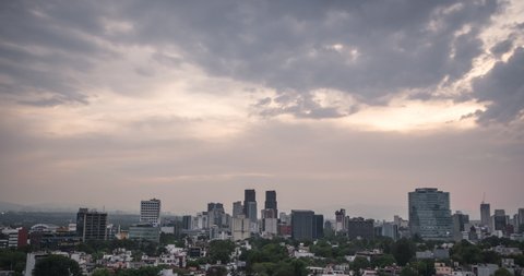 Aerial time lapse of mexico city buildings the specific Neighborhood  is polanco, amazing sunset with red and orange sky it has many clouds, lights, buildings and skyscrapers in the skyline.