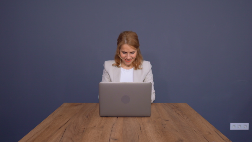 Concentrated Woman In Business Typing Report In Empty Office. Isolated On Grey Background. Business Concept.