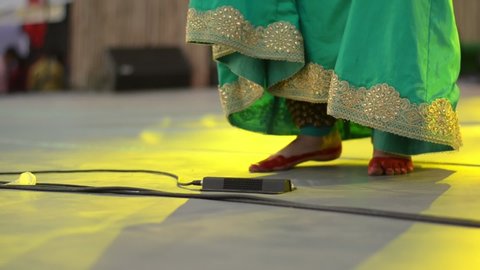 Close up shot of henna feet of an Indian classical dancer wearing Saari and anklet/ghunghroo dancing. Folk dances like Bharatnatyam, kathak etc emphasize on both hand and feet movement coordination 