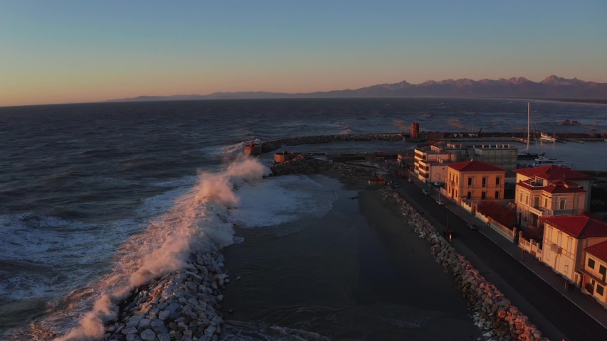 Magical sunset with huge waves over Mediterranean sea near the coast of Pisa in Italy. Huge waves crushing the coast. Royalty-Free Stock Footage #1044183304